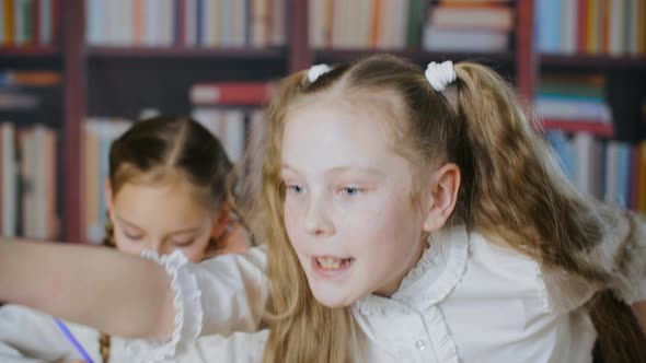 Cute Schoolgirl Standing Up From Chair, Talking and Pointing alt