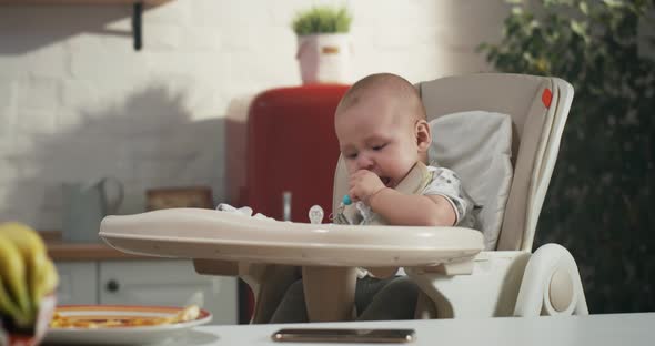 Baby Playing in a High Chair alt