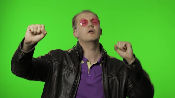 Playful Rocker Man in Pink Sunglasses Moving in Dance, Smiling, Making Dab Poses, Gesture of Success alt