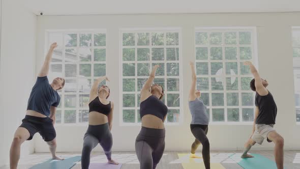 Group of young people practicing yoga lesson in exercise classroom alt