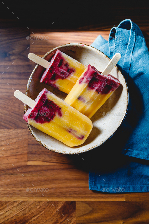 Fruit homemade popsicles made are from fresh mango, blackcurrant and coconut milk