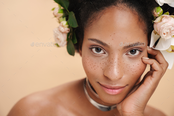 Portrait of half-naked african american woman with flowers in her hair