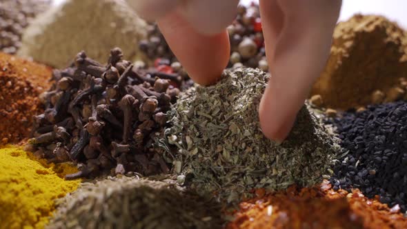 Human Hand Holds and Press a Pinch of a Fragrant Herbs By a Hand Over alt