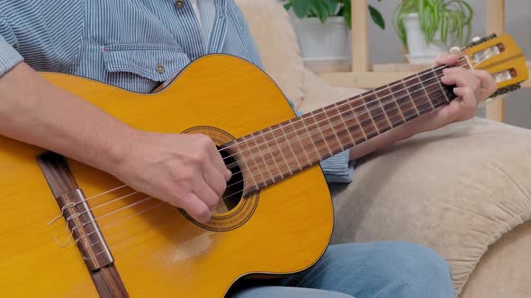Senior Man Plays Acoustic Guitar and Sings in Apartment Living Room alt