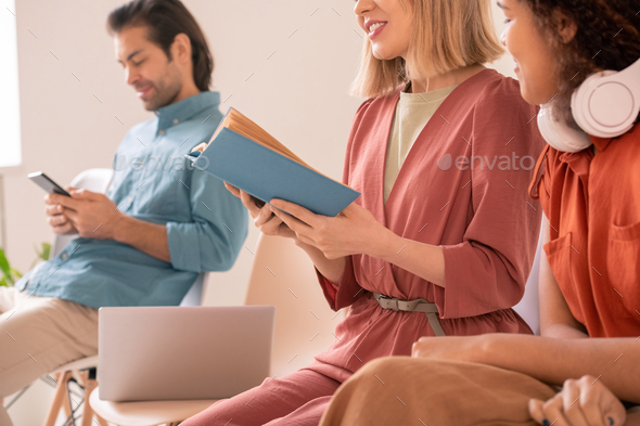 Woman sharing impressions by book with friend