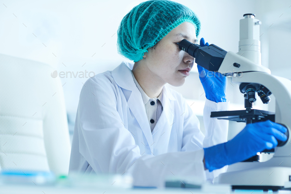 Woman examining samples with microscope