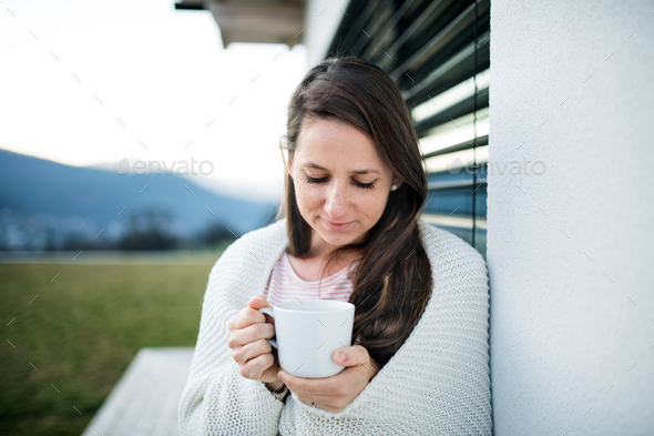 Woman with coffee outdoors at home, Corona virus and quarantine concept
