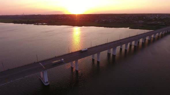 Aerial Shot of a Rangy Bridge with a Riding Truck in Ukraine at Sunset in Summer