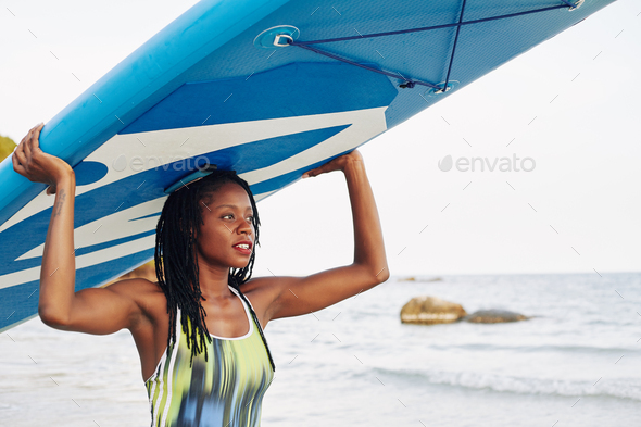 Woman carrying sup surfing board