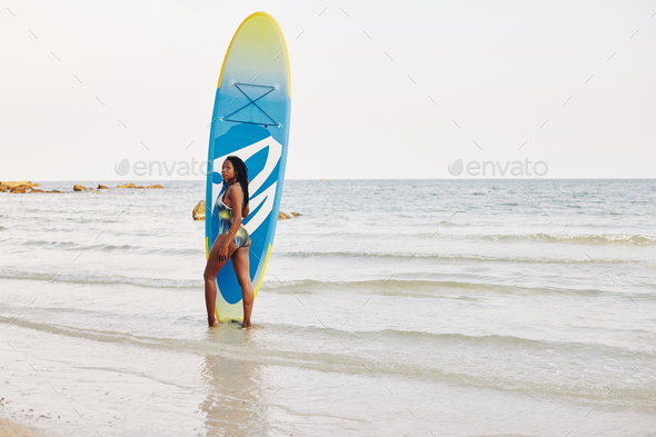 Fit woman with sup surfing board