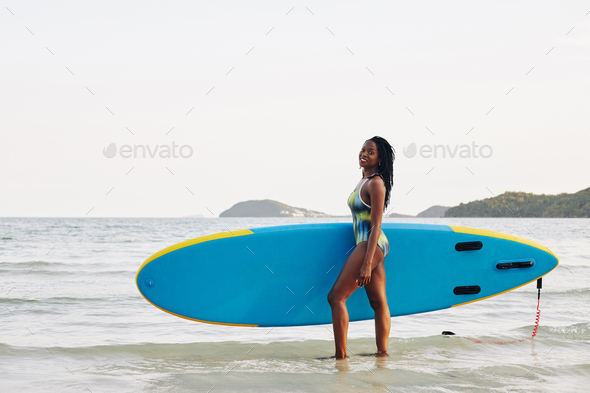 Happy woman with sup surfing board