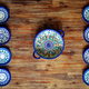 Detail of painted ornate pottery plates on wooden textured table in vintage style - PhotoDune Item for Sale