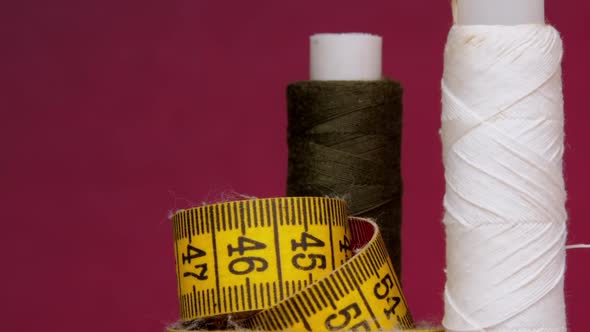 Brown and White Threads on Spools Near Yellow Measuring Tape alt