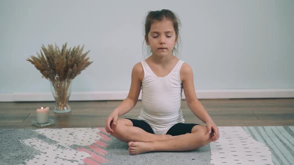 Caucasian Girl Does Yoga Baby Sits in the Lotus Position and Yawns Girl is Tired Yoga for Beginners