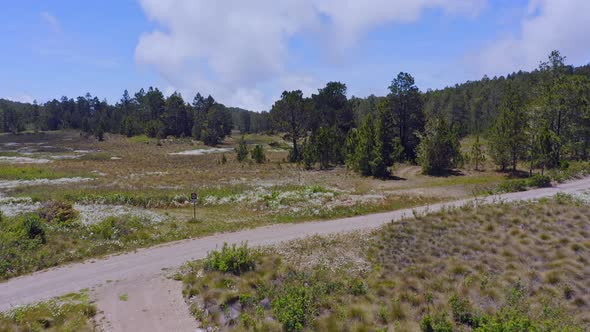 Drone pov over dirt country road junction at Valle Nuevo National Park in Dominican Republic. Aerial alt
