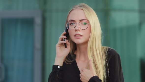 Worried Nervous Caucasian European Blonde Woman Holding Mobile Phone Angrily Talking to Bank Service alt
