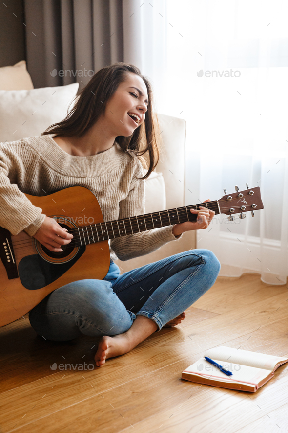Image of nice beautiful woman playing guitar and singing song