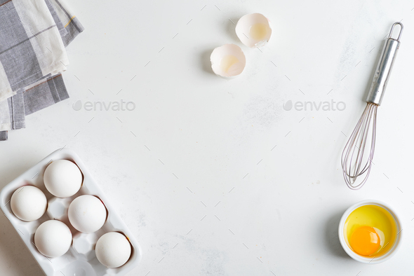 Ceramic box with natural organic farm eggs and metal whisk on a stone kitchen table - Stock Photo - Images