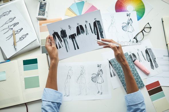 Designer examining sketches of clothes
