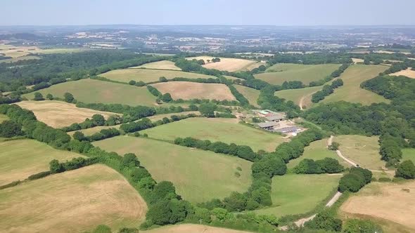 Drone footage of vast green fields and meadows of a beautiful countryside landscape. alt