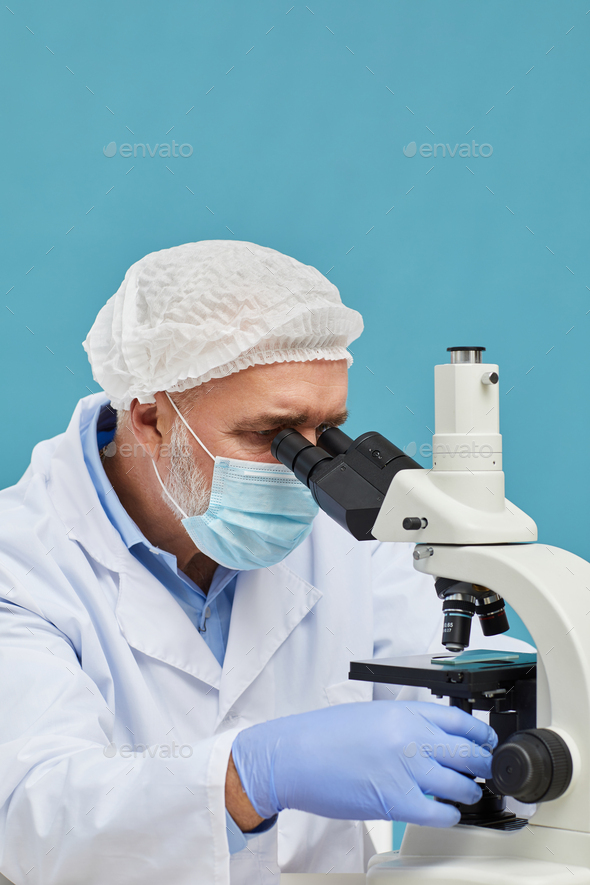 Doctor using microscope Stock Photo by AnnaStills PhotoDune