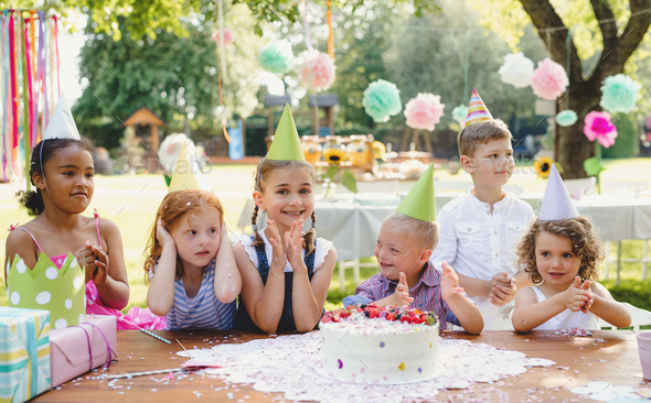 Down syndrome child with friends on birthday party outdoors in garden ...