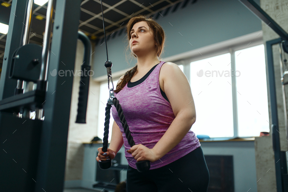 Overweight woman doing stretching exercise in gym