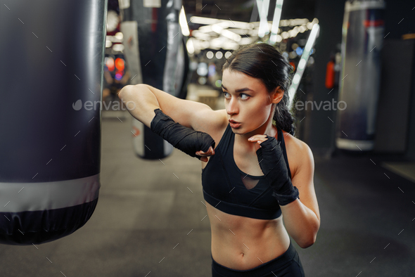 Woman hits a punching bag, thai boxing training - Stock Photo - Images