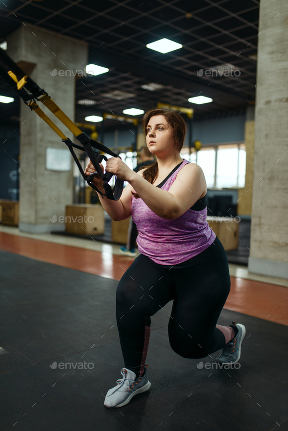 Overweight woman doing stretching exercise in gym