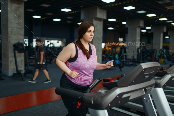 Overweight woman, exercise on treadmill in gym - Stock Photo - Images