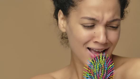 Beauty Portrait of Young African American Woman Dancing and Singing Merrily in Hairbrush alt