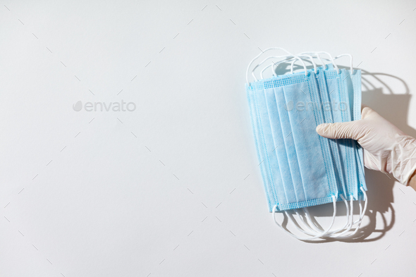 Woman hands in latex gloves holding facial medical masks, white background, close up - Stock Photo - Images