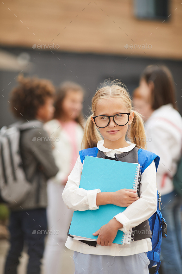 Schoolgirl with textbooks outdoors - Stock Photo - Images