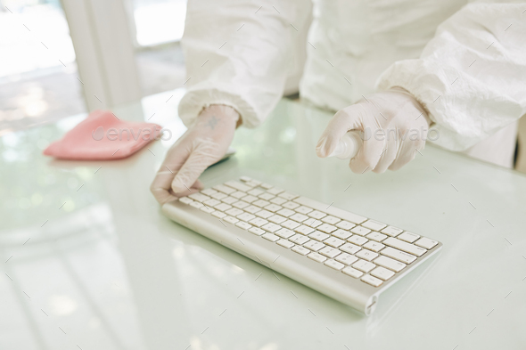 Worker disinfecting keyboard