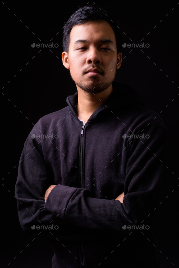 Portrait of young man wearing hoodie with his arms crossed stock