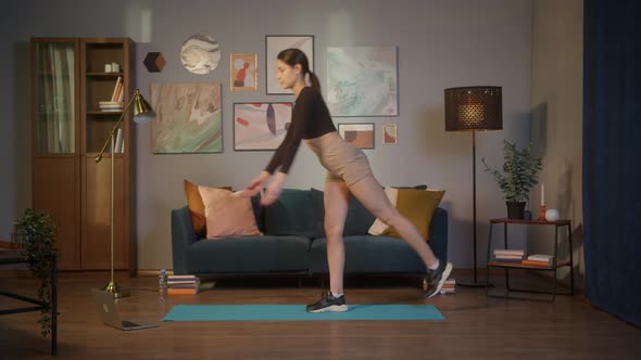 Fit Young Woman Doing Yoga Stretching Exercises with Laptop Online at Home alt