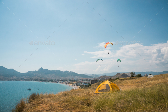 People Flying on Paragliders at Sea, Camping on Foreground, Ukraine, Crimea