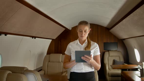 Business Woman in Air Private Jet Surfing Internet on tabletPC alt