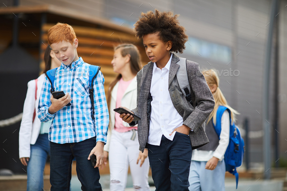 Schoolboys talking on mobile phones - Stock Photo - Images