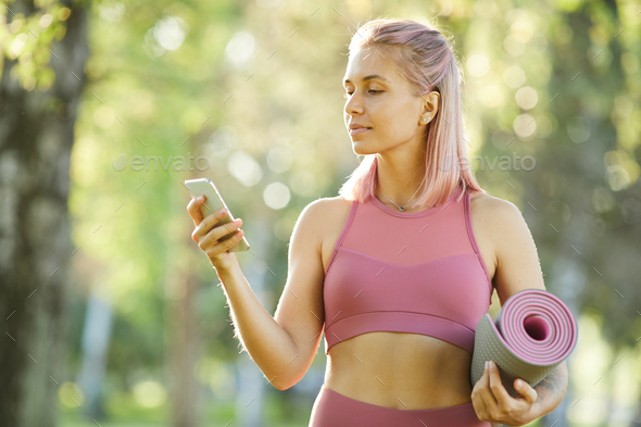 Sporty woman using phone - Stock Photo - Images