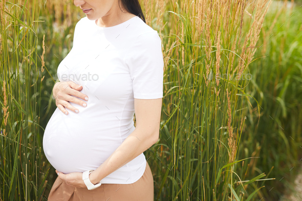 Pregnant woman against the rural scene - Stock Photo - Images