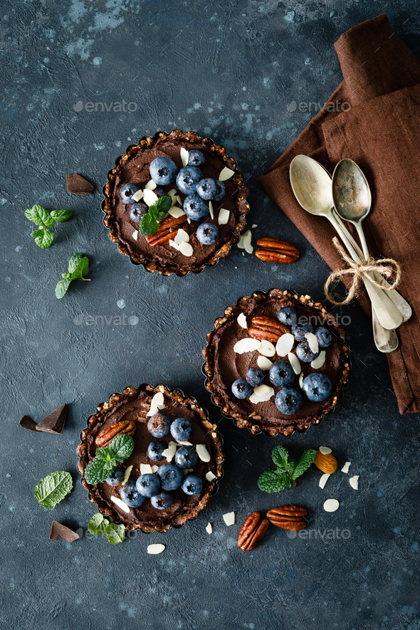 Healthy raw vegan dessert dates tartlets with chocolate cream - Stock Photo - Images