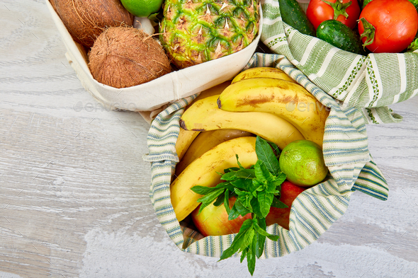 Flat lay of eco friendly grocery shopping cotton bags with organic fruits and vegetable - Stock Photo - Images