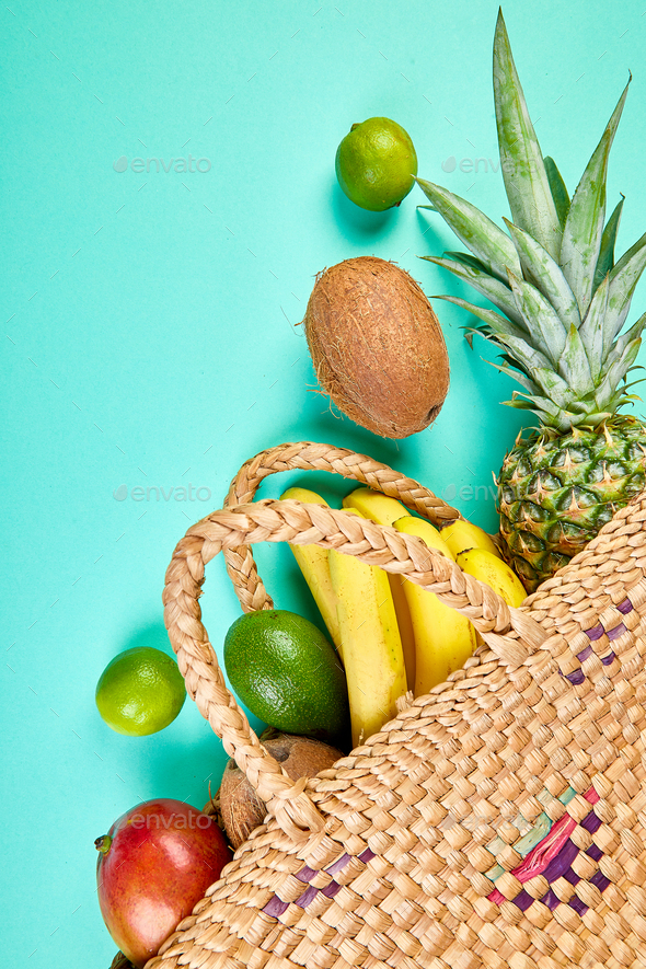 Grocery shopping bamboo bag with organic exotic fruits on blue background. - Stock Photo - Images