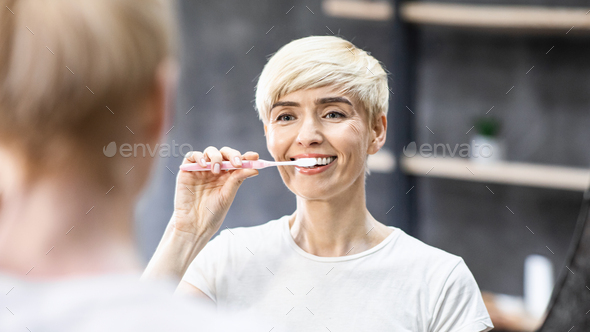 Smiling Lady Cleaning Teeth With Toothbrush In Bathroom, Panorama - Stock Photo - Images