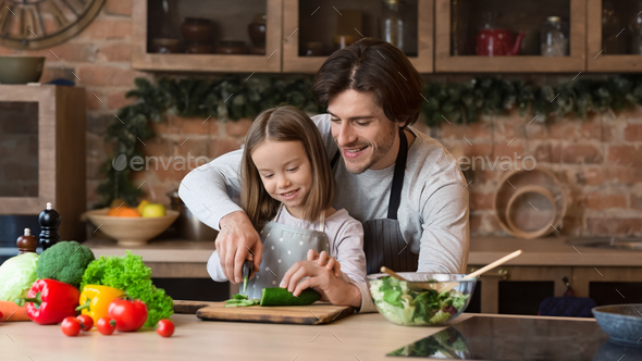 Daddy Teaching Little Daughter How To Use Knife In Kitchen