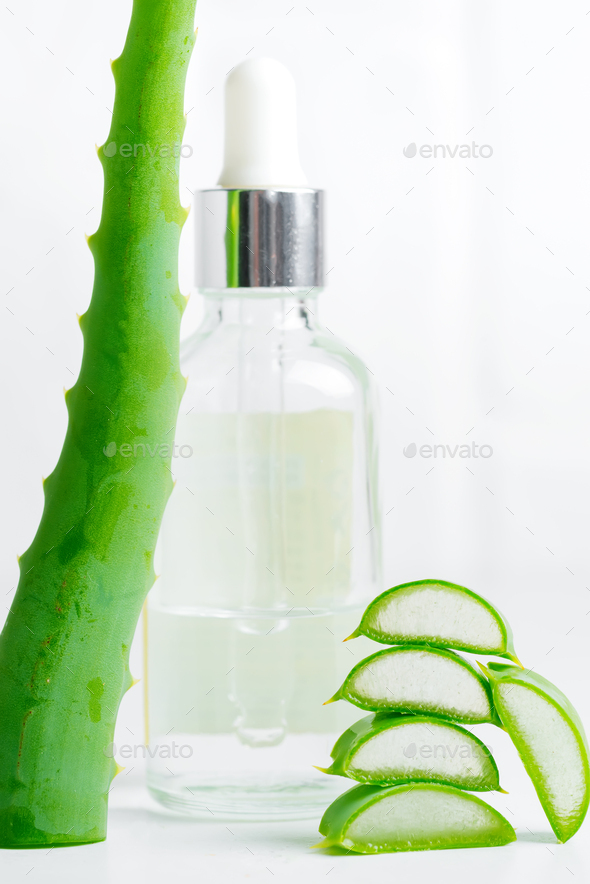 Sliced organic aloe vera plant and cosmetic bottle with natural lotion against light grey background - Stock Photo - Images
