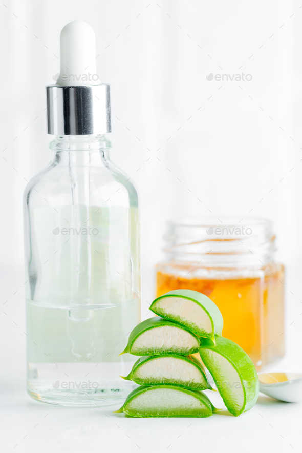 Cosmetic homemade lotion or essential oil from natural sliced aloe vera plant in glass bottles - Stock Photo - Images