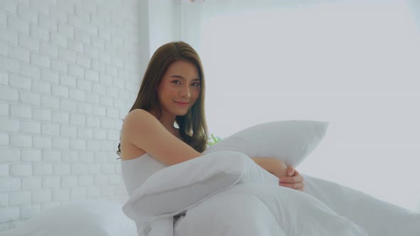 Portrait ot beautiful attractive asian young woman smile and hug pillow alt