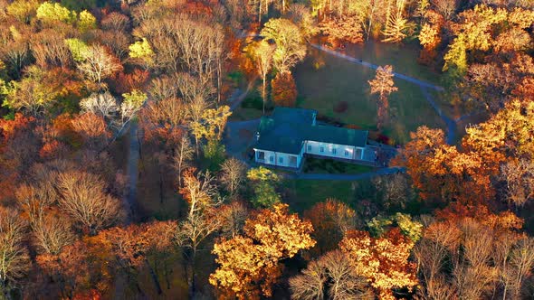 Flight in the evening over trees, park, building. The trees are covered with red, yellow. alt